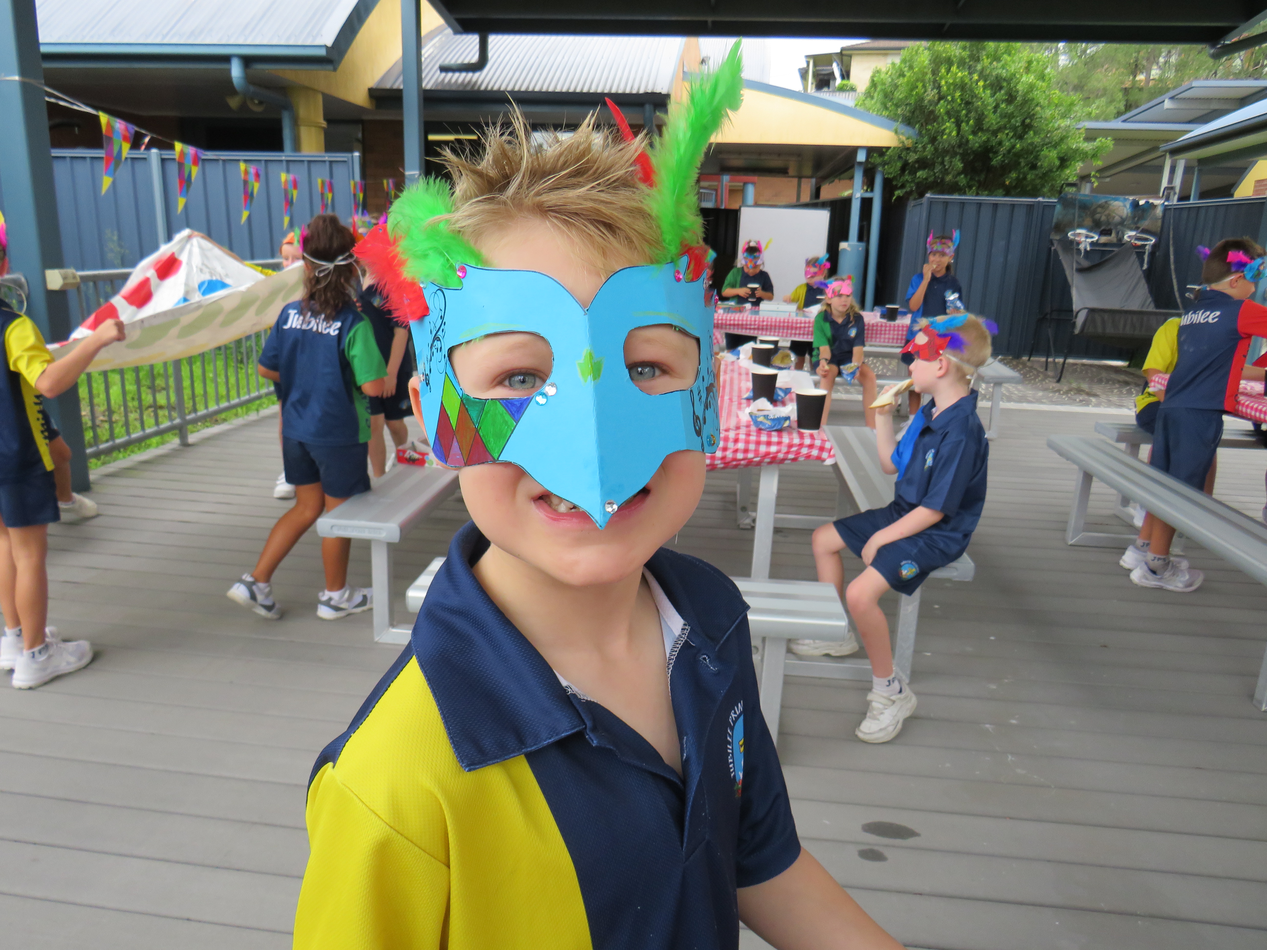students wearing crafted masks for italian carnival theme lesson outaide on the deck 