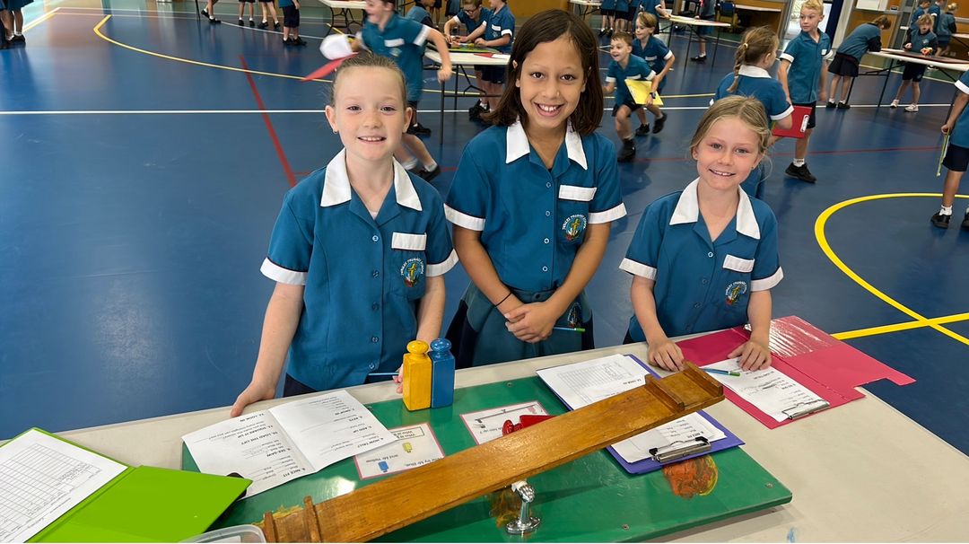 students in hall playing hands on maths games with a seesaw