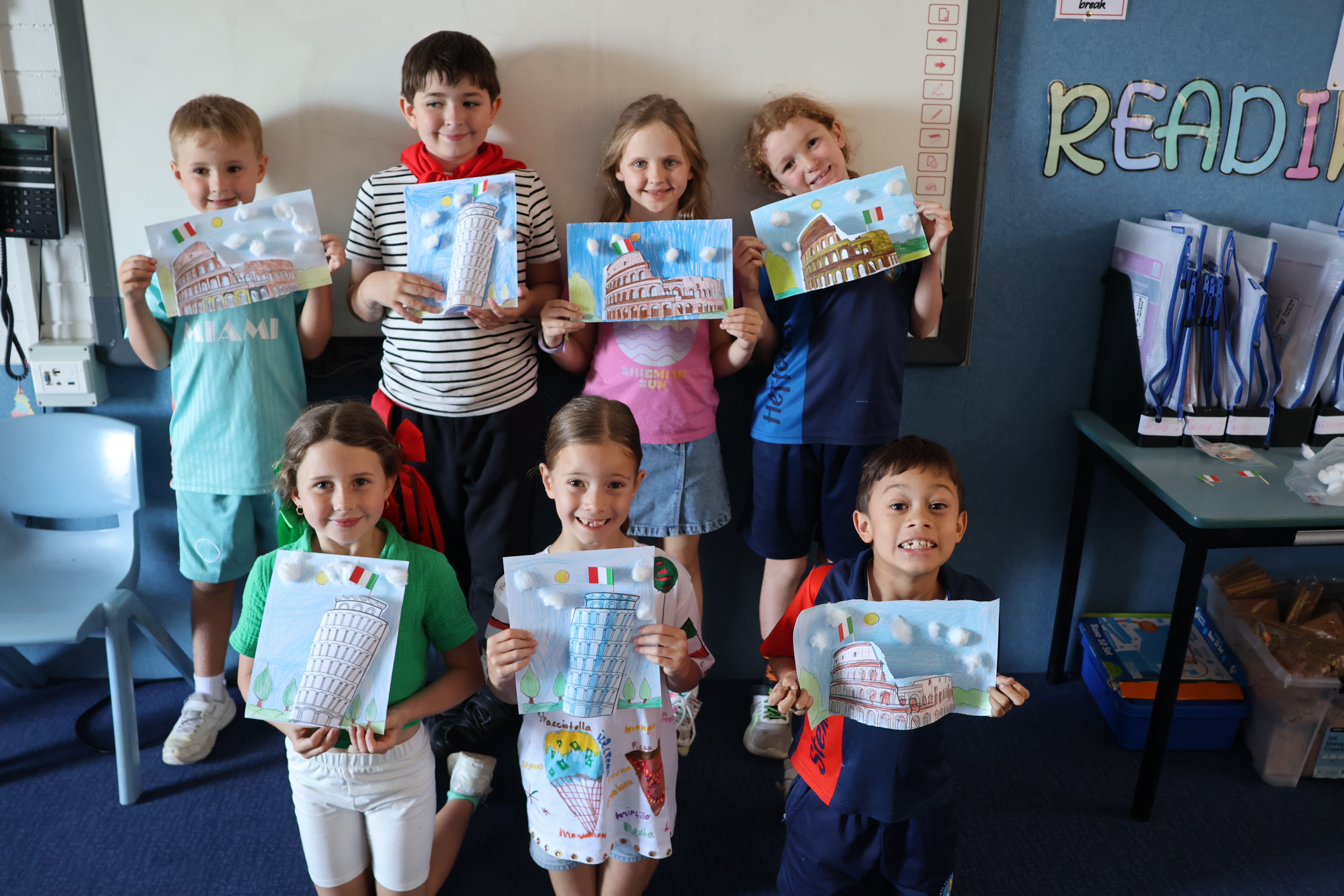 studnets dressed in italian attire holding collage artwork of tower of pisa