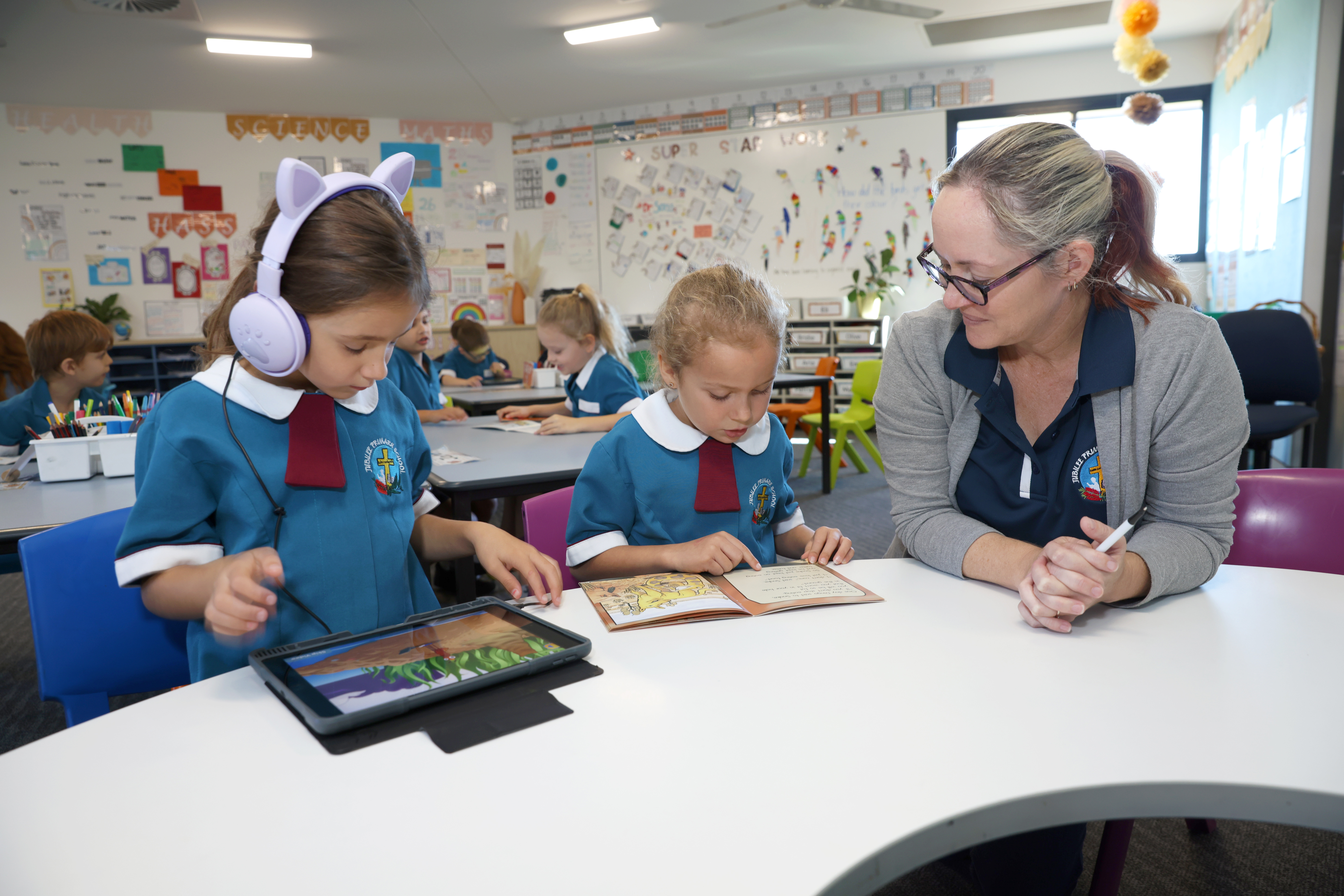 students using ipad in class with teacher 